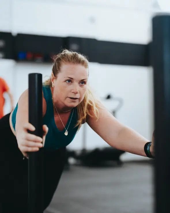 Woman pushing sled in class